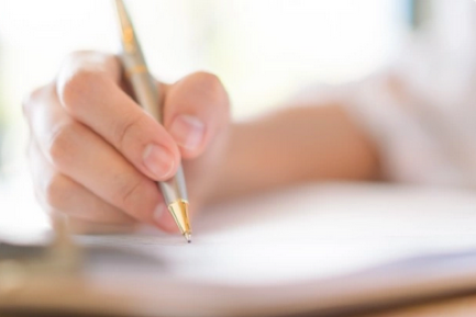 main qui tient un stylo